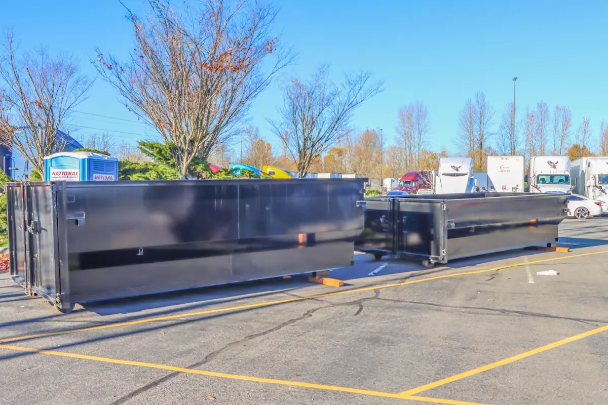 Professional dumpster rental service with roll-off container on residential driveway in River Ridge